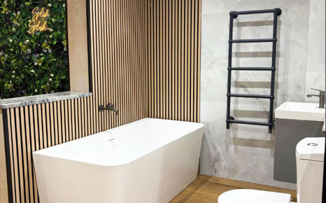 Interior view of a bathroom featuring a stylish freestanding bathtub, modern toilet, and sleek basin, accented by wooden elements and contemporary design.