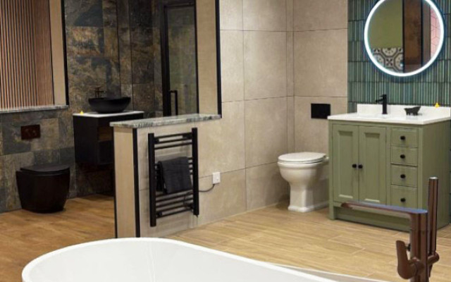 A spacious bathroom showroom featuring a large bathtub and a modern basin.